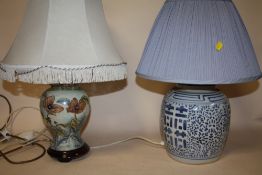 AN ORIENTAL STYLE BLUE AND WHITE CERAMIC TABLE LAMP TOGETHER WITH A FLORAL EXAMPLE