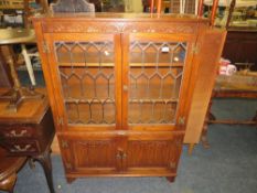A REPRODUCTION OAK LINENFOLD GLAZED - JAYCEE BOOKCASE W-98 CM