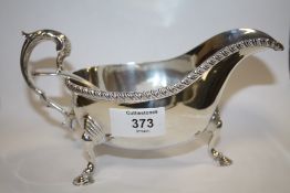 A HALLMARKED SILVER SAUCE BOAT TOGETHER WITH A PLATED LADLE