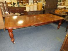 A LARGE MID VICTORIAN OAK WIND-OUT EXTENDING DINING TABLE ON BALUSTER SUPPORTS WITH TWO ADDITIONAL