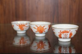 THREE SMALL CHINESE/ORIENTAL TEA BOWLS WITH ORANGE BACK STAMPS