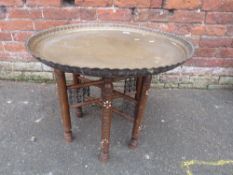 AN EASTERN BRASS TOP TABLE WITH TYPICAL INCISED DECORATION - FOLDING STAND H-53 CM DIA. 67 CM