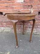 AN ART DECO STYLE WALNUT CIRCULAR GAMES TABLE ON FOUR CABRIOLE SUPPORTS - ONE LEG SEPARATE H-68 CM