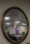 AN OVAL FRAMED MIRROR, APPROX. 78 X 54 CM