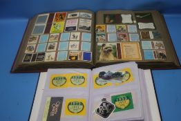 A SCRAP BOOK OF MATCH BOX COVERS, together with a smaller album containing transport related