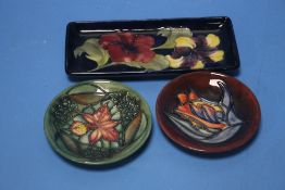 THREE MOORCROFT DISHES COMPRISING TWO PIN DISHES AND A RECTANGULAR TRAY