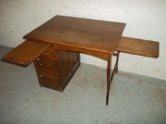 A SMALL ANTIQUE OAK KNEEHOLE DESK WITH DRAWERS AND PULL OUT SHELVES