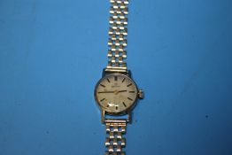 A LADIES OMEGA MANUAL WIND WRIST WATCH on an unbranded 9 ct gold strap, dedication inscription to