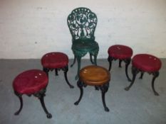 FIVE CAST IRON PUB TABLE STOOLS AND AN IRON GARDEN CHAIR