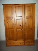A MODERN TRIPLE DOOR PINE WARDROBE WITH TWO DRAWERS AND BUN FEET (UNATTACHED)