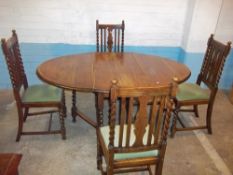 AN ANTIQUE OAK DROPLEAF DINING TABLE WITH FOUR CHAIRS, BARLEY TWIST LEGS