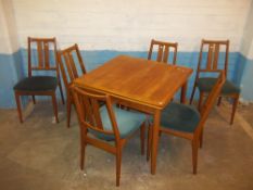 A TEAK EXTENDING DINING TABLE WITH SIX CHAIRS ( ONE CHAIR LEG REPAIRED)