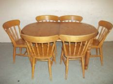 A SOLID PINE EXTENDING OVAL DINING TABLE SET WITH SIX CHAIRS
