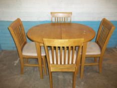 A MODERN EXTENDING OVAL DINING TABLE AND FOUR CHAIRS