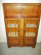 AN EARLY 1900S OAK BOOKCASE WITH SLIDING GLASS DOORS