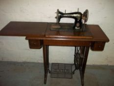 AN ANTIQUE SINGER TREADLE SEWING MACHINE AND TABLE