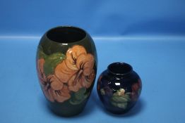 A MOORCROFT 'HIBISCUS' VASE, H 20 CM TOGETHER WITH A MOORCROFT 'ANEMONE' BULBOUS VASE, 10 CM (2)