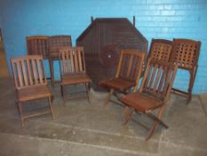 A FOLDING WOODEN GARDEN TABLE AND EIGHT CHAIRS SET