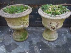 TWO LARGE RECONSTITUTED STONE PLANTERS AND STANDS/PLINTHS WITH LION'S HEAD DETAIL