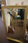 A LARGE GILT FRAMED MIRROR, 130 X 75 CM