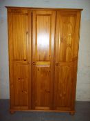 A MODERN PINE TRIPLE DOOR WARDROBE ON BUN FEET