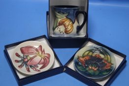 A BOXED MOORCROFT MUG TOGETHER WITH TWO MOORCROFT PIN DISHES (3)