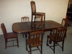 AN OAK EXTENDING DINING TABLE WITH SIX CHAIRS