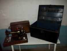 AN ANTIQUE SINGER SEWING MACHINE AND A METAL STORAGE / TRAVEL TRUNK