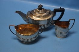 A HALLMARKED THREE PIECE SILVER TEA SET COMPRISING TEAPOT, CREAM JUG AND SUGAR