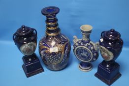 A LARGE COLOURED GLASS VASE. A BLUE & WHITE POTTERY VASE AND TWO CONTINENTAL STYLE URNS WITH