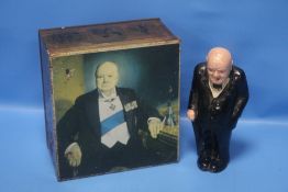 A WINSTON CHURCHILL FIGURE (NO MAKER'S MARK AND MISSING CIGAR) TOGETHER WITH A METAL TIN ALSO
