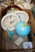 A BOX CONTAINING THREE CLOCKS, GLOBE OF THE WORLD, TWO CARBON MONOXIDE MONITORS AND A CAMERA