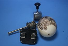 A WHITE METAL TIBETAN PRAYER WHEEL and a carved ostrich egg depicting wild animals, a bakelite