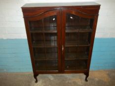 A GLAZED TWO DOOR BOOKCASE WITH QUEEN ANNE LEGS