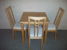 A MODERN KITCHEN TABLE AND THREE CHAIRS
