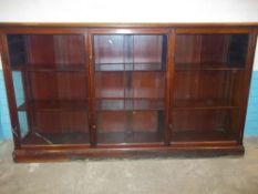 A LIBRARY STYLE DISPLAY BOOKCASE UNIT WITH SLIDING DOORS