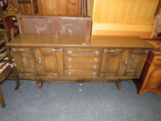 A CARVED OAK ERCOL STYLE SIDEBOARD H-80 W-186 CM