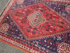 A VINTAGE EASTERN RED WOOLLEN RUG 137 X 106 CM