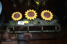 A MODERN CAST METAL SUNFLOWER SHAPED FOUR HOOK COAT RACK