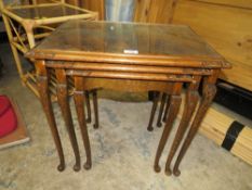 A WALNUT GLASS TOPPED NEST OF TABLES