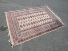A VINTAGE EASTERN WOOLLEN RUG 182 X 128 CM