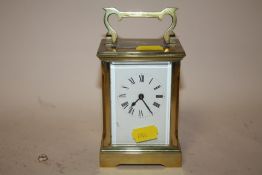 AN ANTIQUE BRASS AND GLASS CASED CARRIAGE CLOCK