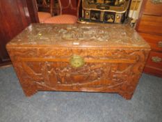 A CARVED EASTERN HARDWOOD COFFER H-56 W-101 CM S/D