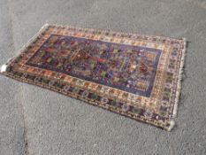 AN EASTERN WOOLLEN RUG WITH MAINLY BLUE GROUND 192 X 105 CM