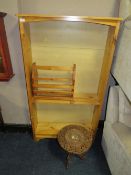 A HONEY PINE OPEN BOOKCASE WITH CARVED EASTERN STYLE TABLE AND A MAGAZINE RACK