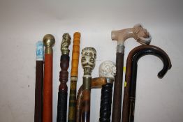 A COLLECTION OF MOSTLY MODERN WALKING STICKS AND CANES TO INCLUDE A SKULL TOPPED EXAMPLE, COMPASS