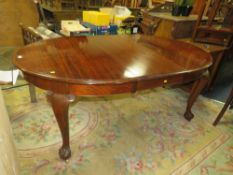 AN EARLY 20TH CENTURY MAHOGANY WIND-OUT DINING TABLE RAISED ON CABRIOLE SUPPORTS AND BALL AND CLAW