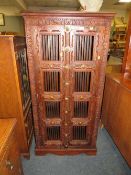 A COLONIAL HARDWOOD TWO DOOR CUPBOARD WITH METAL GRILLS H-153 -76 CM