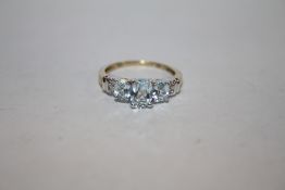 A HALLMARKED 9K GOLD RING SET WITH BLUE TOPAZ STONES AND DIAMOND CHIPS TO THE SHOULDERS APPROX