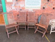 A SET OF FOUR WOODEN FOLDING GARDEN CHAIRS